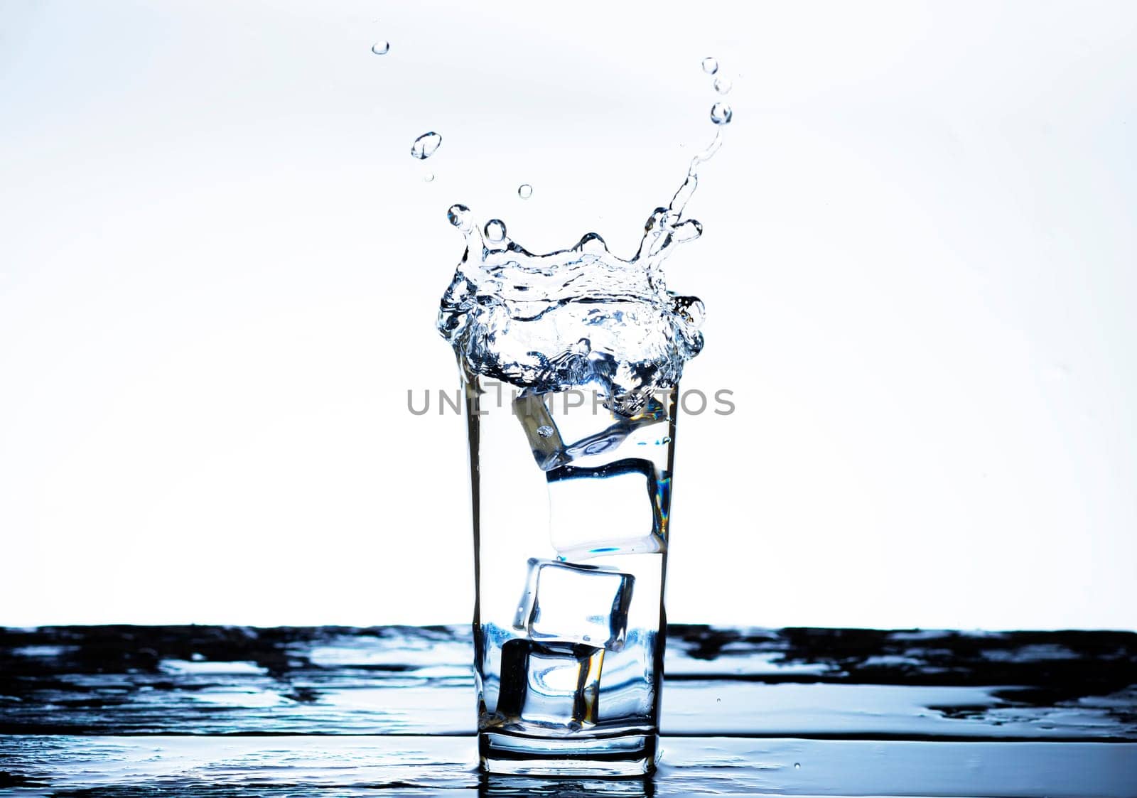 The image of pouring drinking water, into a glass, that makes one feel refreshed on blurred white background, Splashing water, Sparkling water