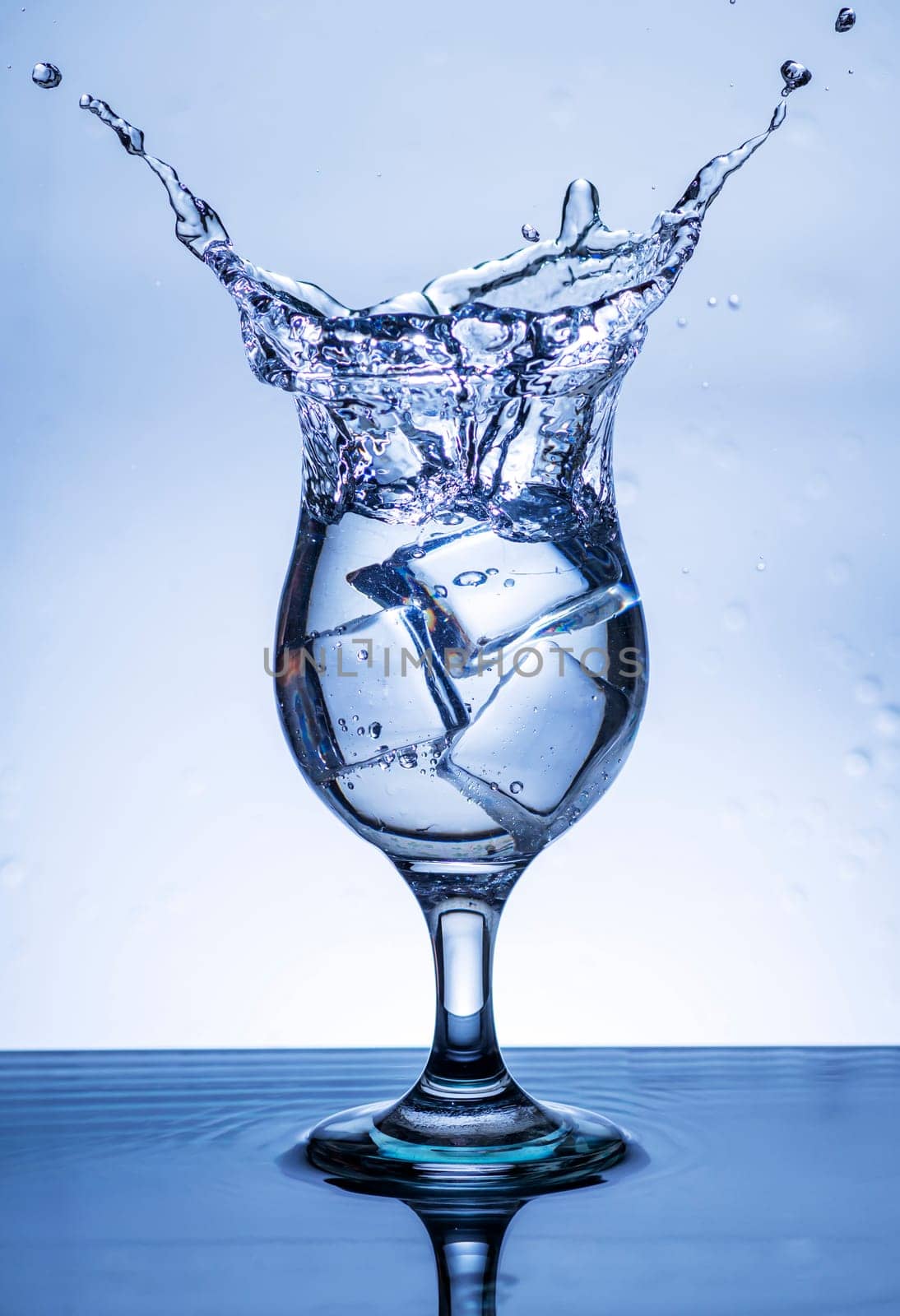 The image of pouring drinking water, into a glass, that makes one feel refreshed on blurred white background, Splashing water, Sparkling water