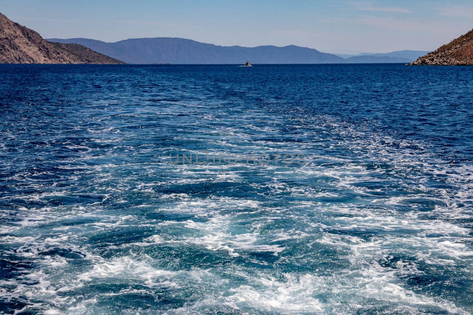 Trail on water surface or powerful stern wave behind of fast moving speedboat or ferry while cruising on ocean. Greek Aegean.