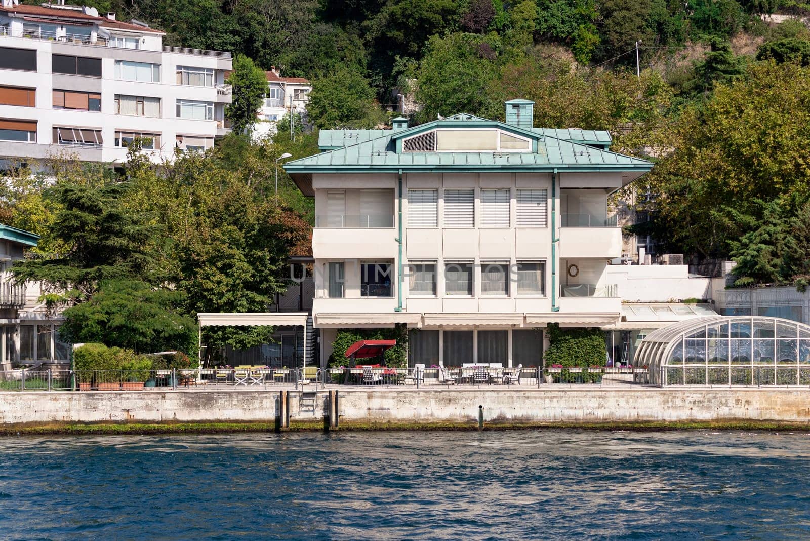 View from Bosphorus strait of the green mountains of the Asian side, with traditional houses and dense trees in a summer day, Istanbul, Turkey