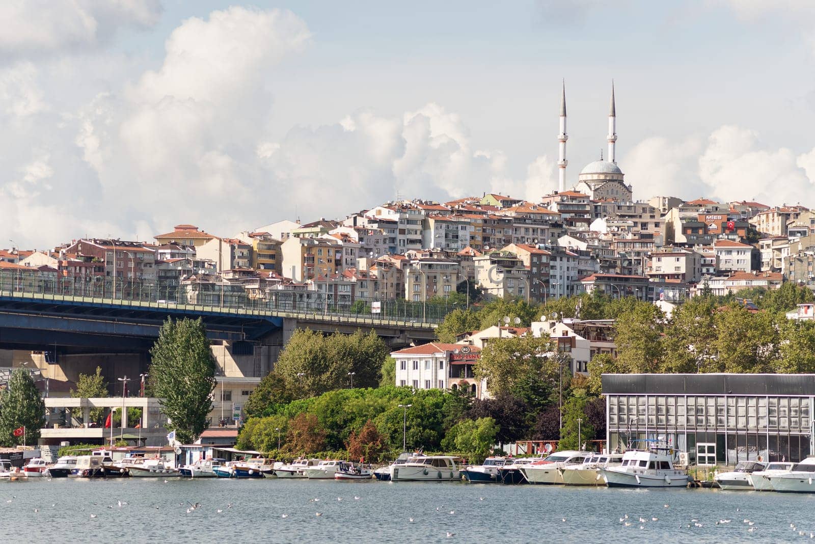 View of the Golden Horn coast with docked ferry boats and Ataturk Bridge in the far end, Istanbul, Turkey