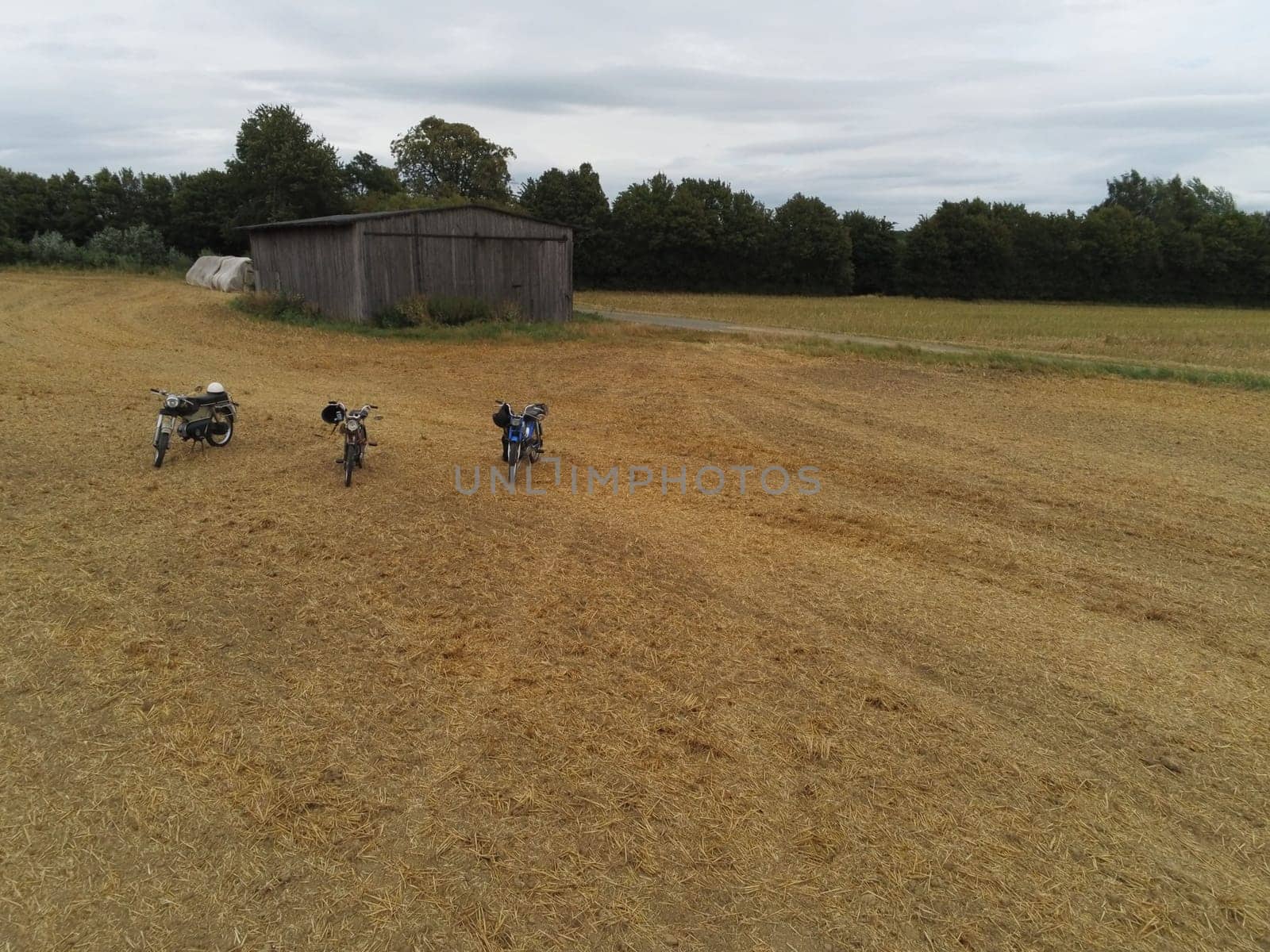 Classic mopeds on a field with a barn in the background in Germany