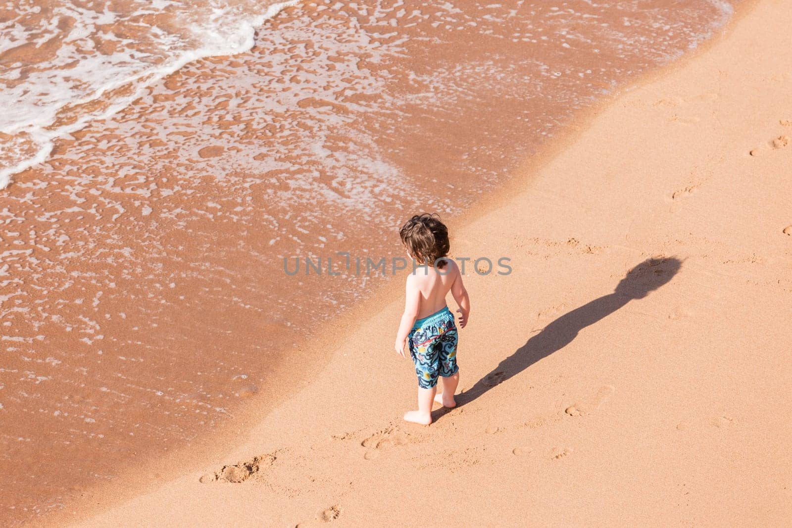 Young boy child on beach ocean water  sands new explore adventure overhead photo.