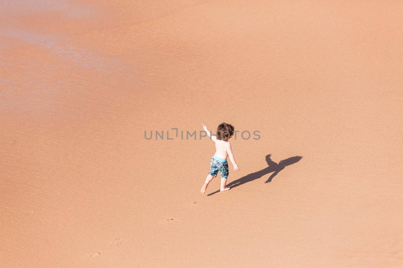 Young boy child on beach ocean water  sands new explore adventure overhead photo.