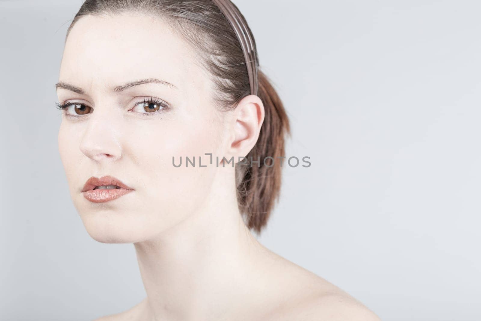 a young woman looks sadly and thoughtfully into the camera