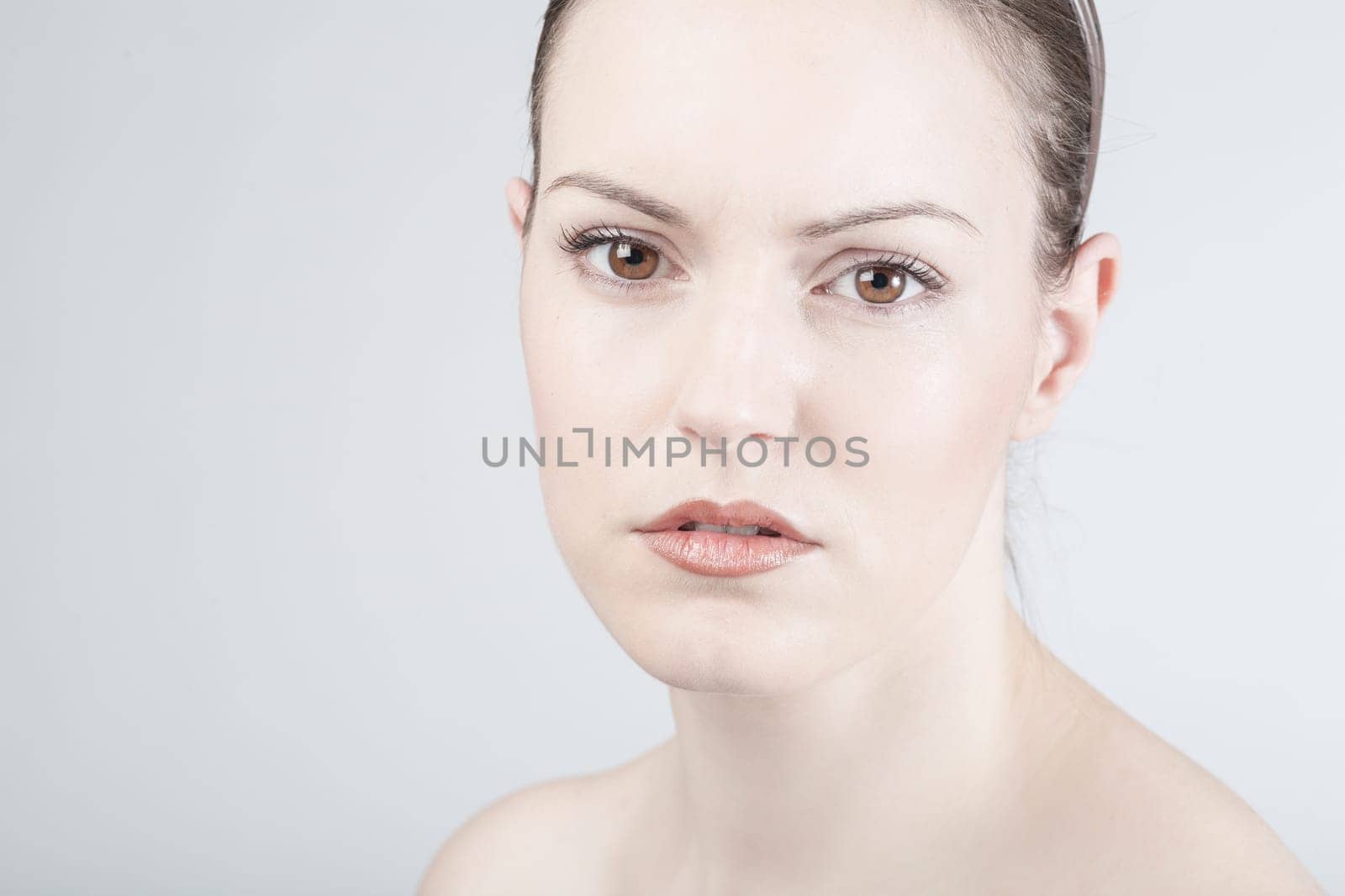 a young woman looks sadly and thoughtfully into the camera