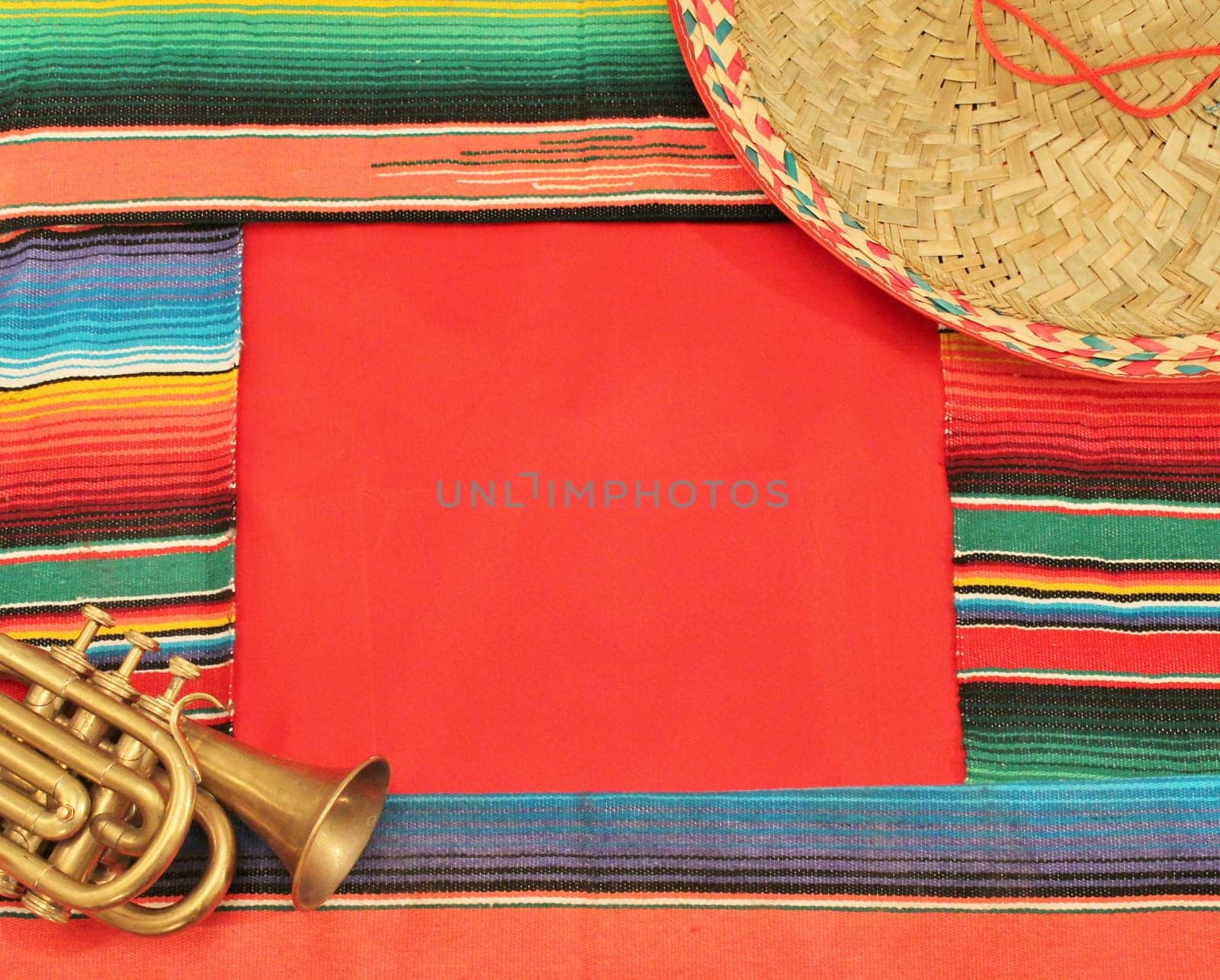 Traditional Mexican fiesta poncho rug in bright colors with sombrero background with copy space frame