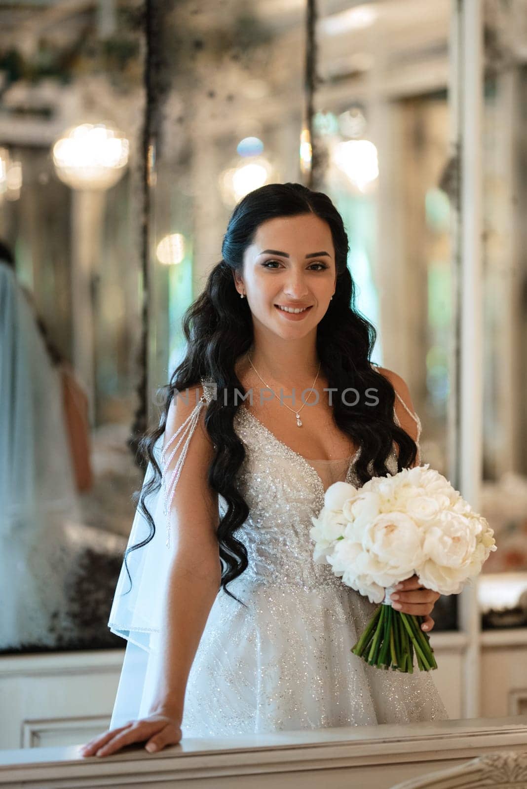 portrait of a bride in a white dress in a bright cafe with mirrors