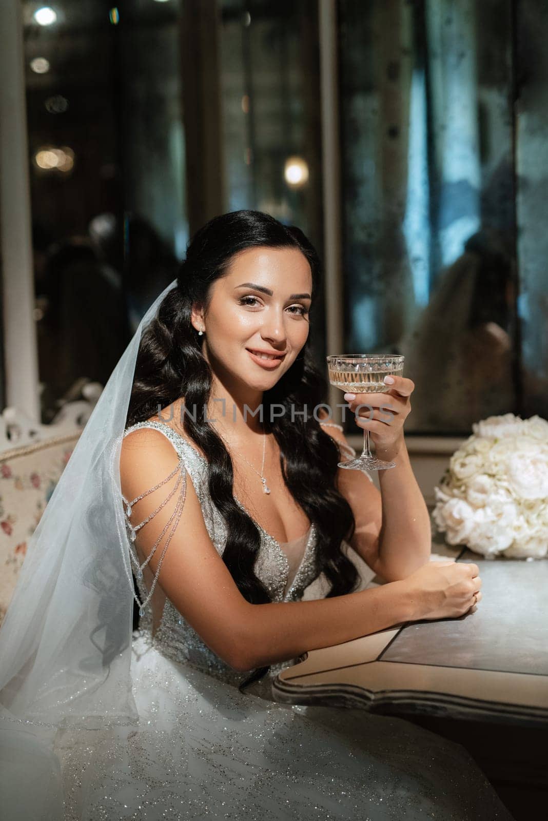 portrait of a bride in a white dress in a bright cafe with mirrors