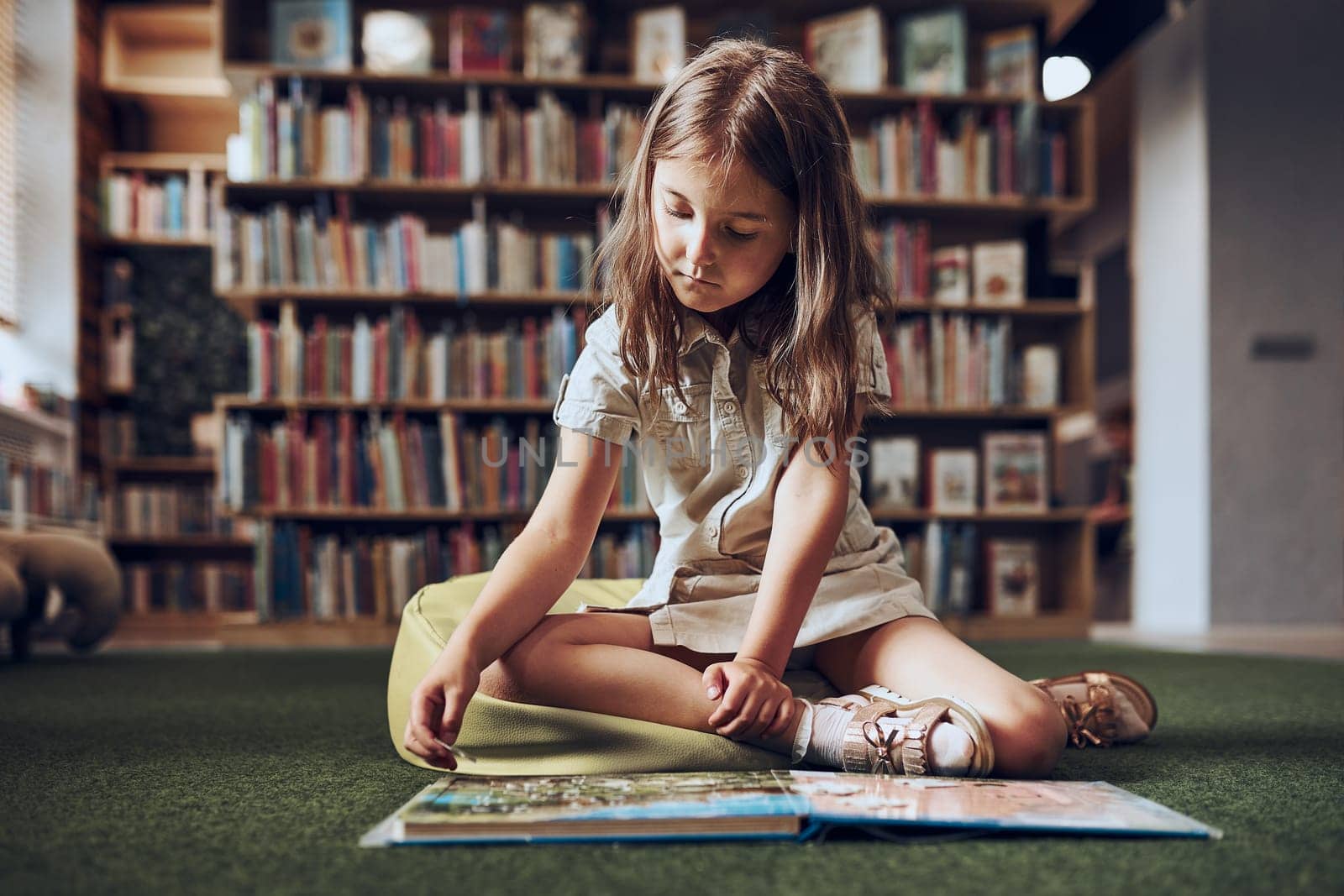 Child solving riddle in book in school library. Primary school pupil is involved in book with riddles. Smart girl learning to solve problems. Benefits of everyday practice. Child curiosity