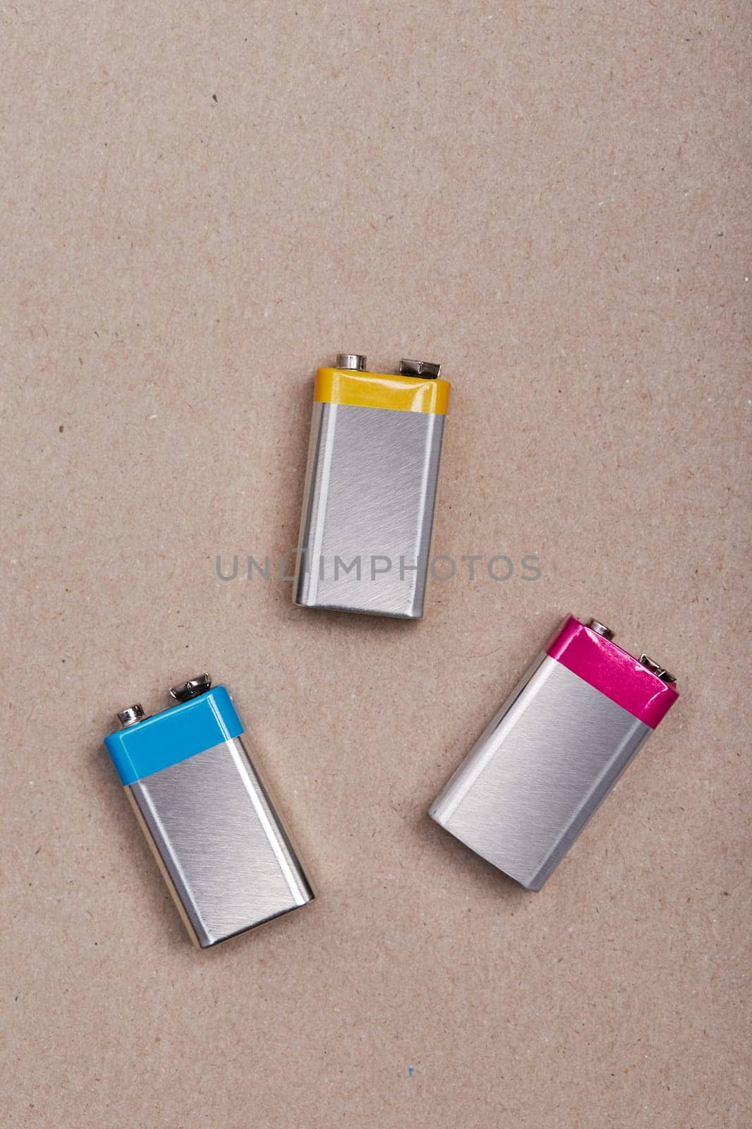 Three discharged batteries on paper background. Collecting used batteries to recycle. Waste disposal and recycling. Copy space for text