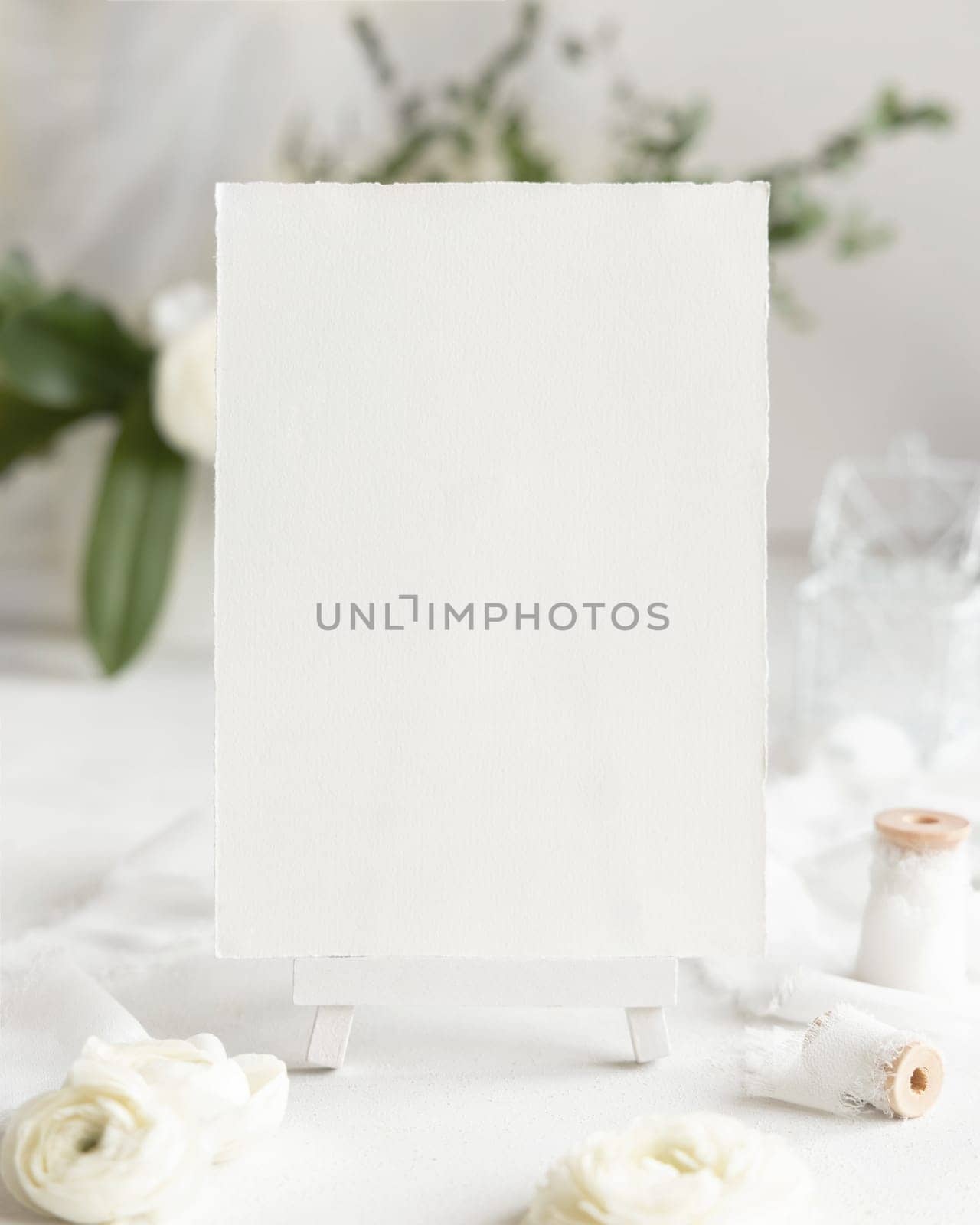 Blank Card near cream roses and white ribbons close up, Wedding mockup. Romantic scene with vertical card and flowers. Valentines, Spring or Mothers day concept