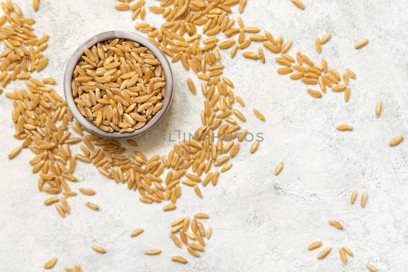 Bowl of raw dry rye grain on white table top view, copy space. Healthy alternative low gluten seeds. Protein source for vegan and vegetarian diet.