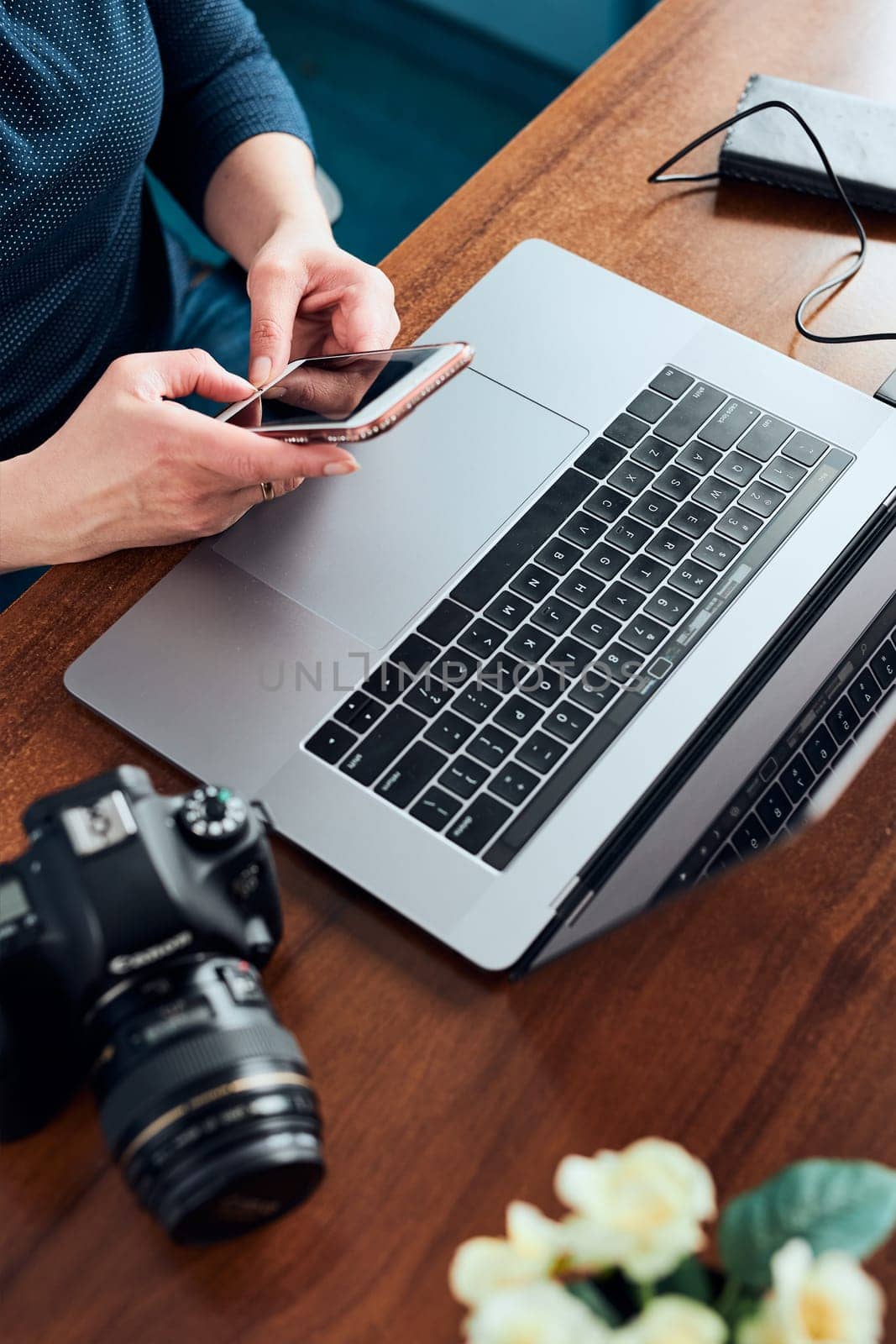 Female photographer working on photos on laptop and camera. Woman editing retouching browsing photos working as a freelancer sitting at desk
