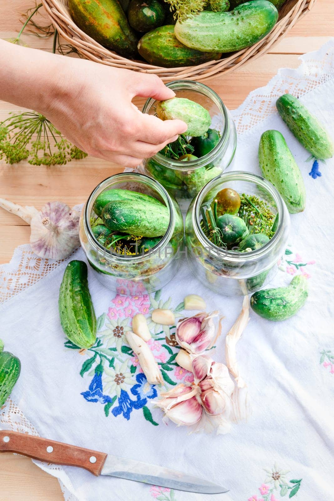Pickling the cucumbers with home garden vegetables and herbs, fresh vegetables picked straight from field, collected on wooden table outdoors. View from above