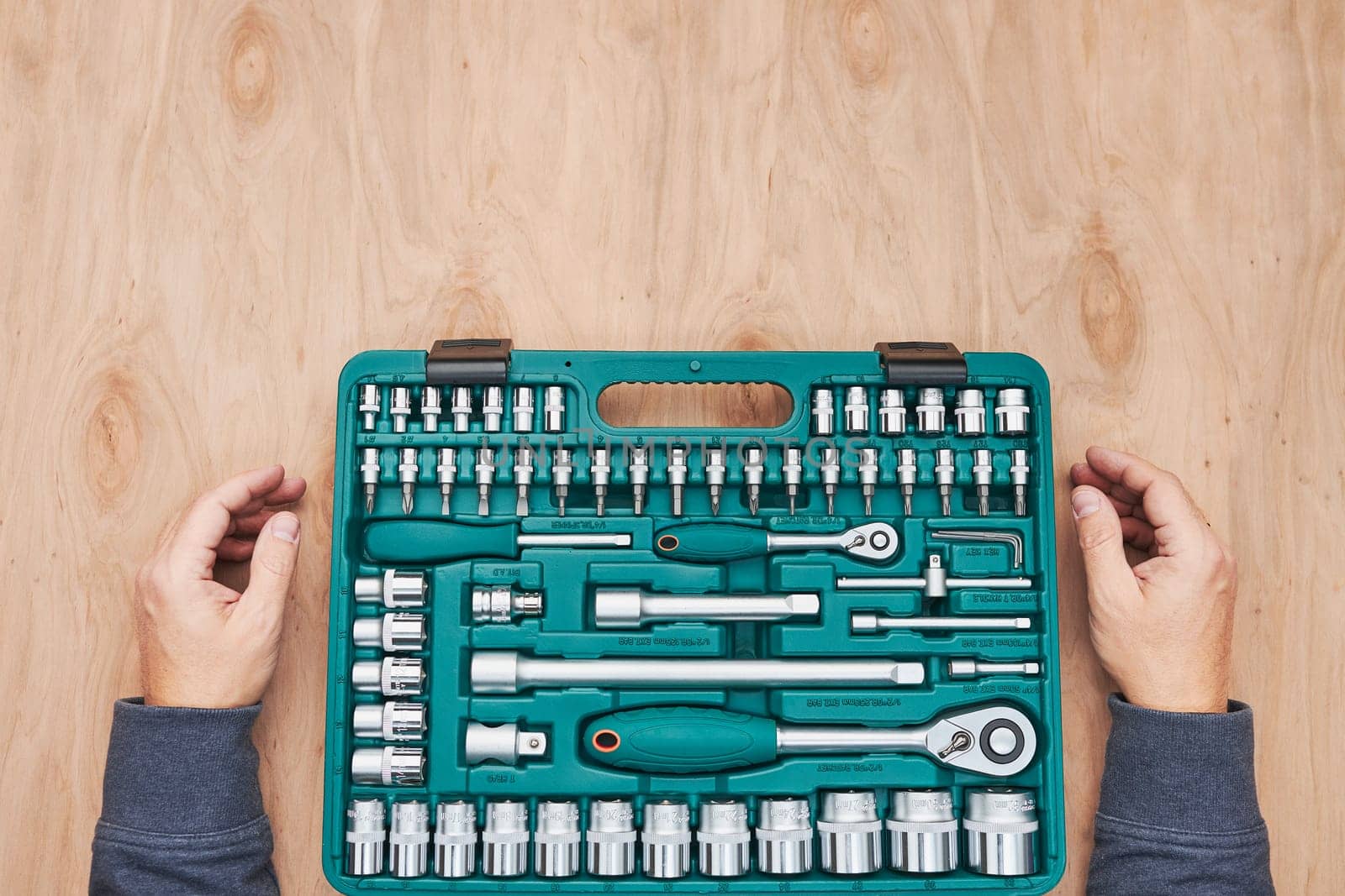 Man preparing tools in workshop. Wrench, spanner and ratchet with many attachments. Work tools. Universal tool set. Professional equipment