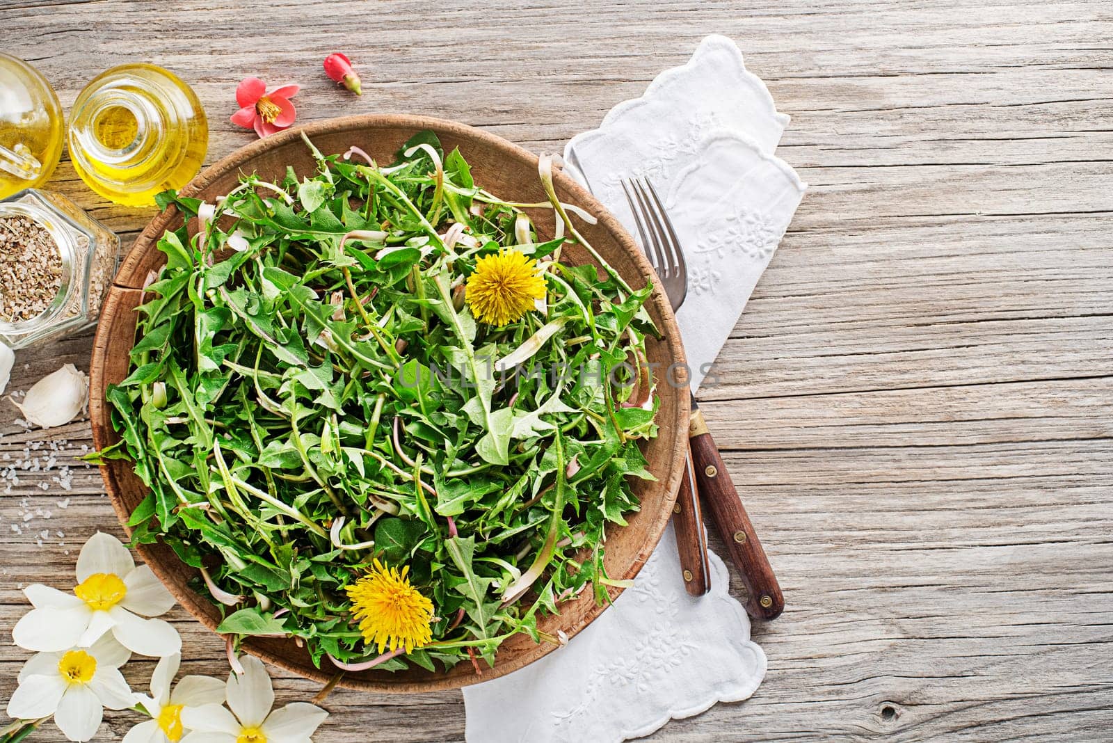 Fresh dandelion salad with dressing. Healthy spring food concept