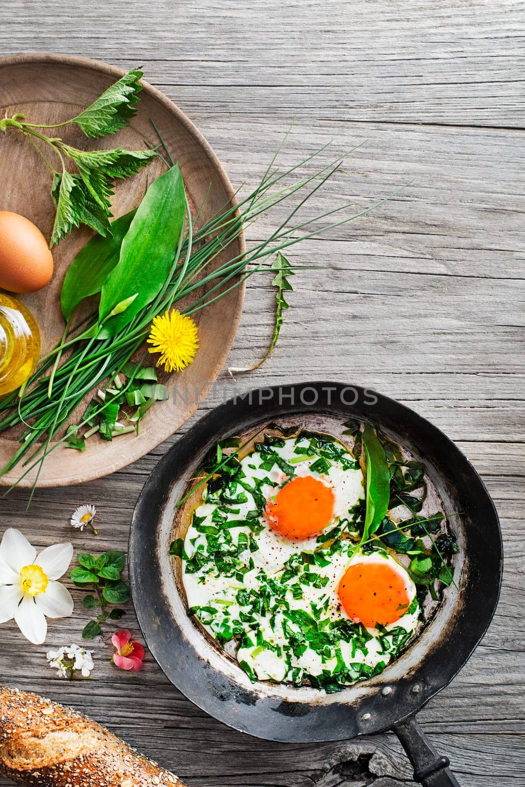Fried eggs with fresh spring plants and herbs. Healthy spring food concept.