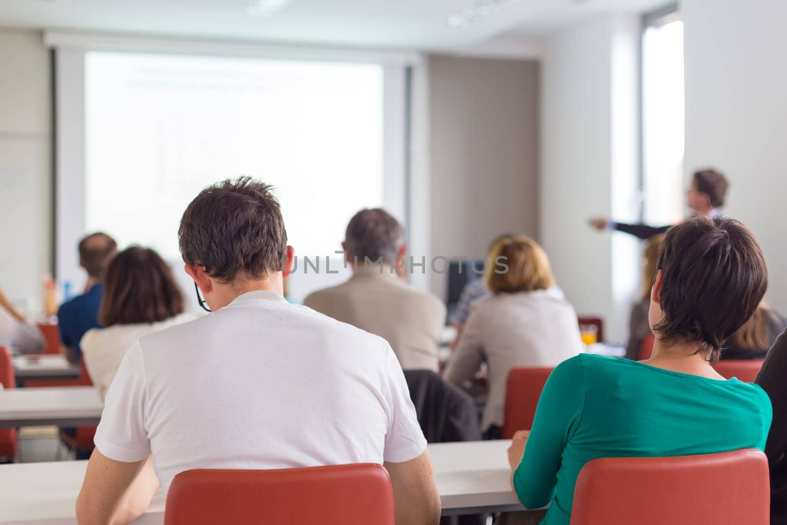 Speaker Giving a Talk at Business Meeting. Audience in the conference hall. Business and Entrepreneurship. Copy space on white board.