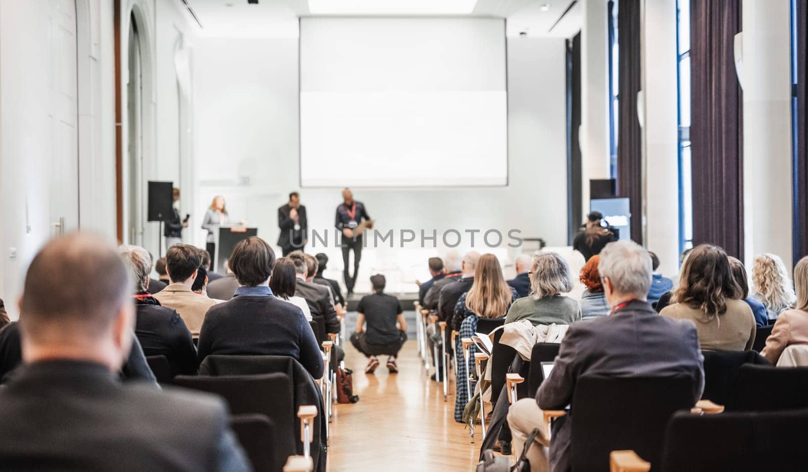 Business team leader receiving award prize at best business project competition event. Business and entrepreneurship award ceremony theme. Focus on unrecognizable people in audience