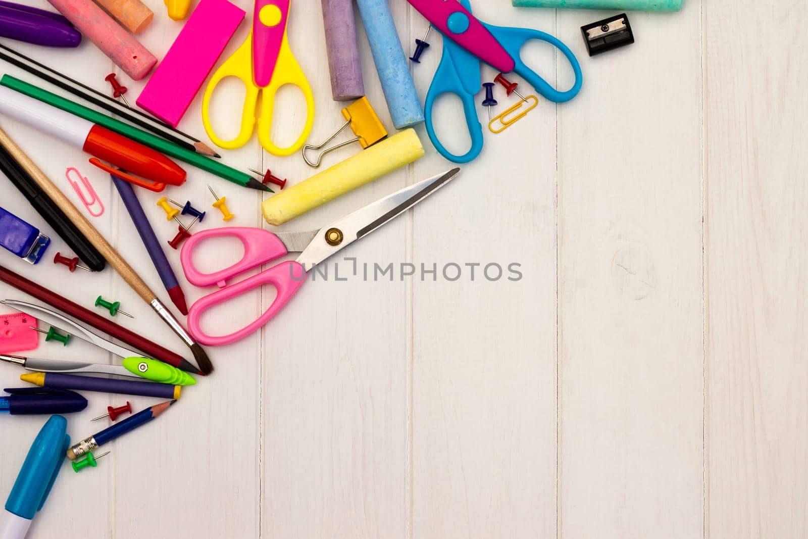 Coloured school supplies on a white wooden background, . Top view. Copy space. Education and back to school concept.