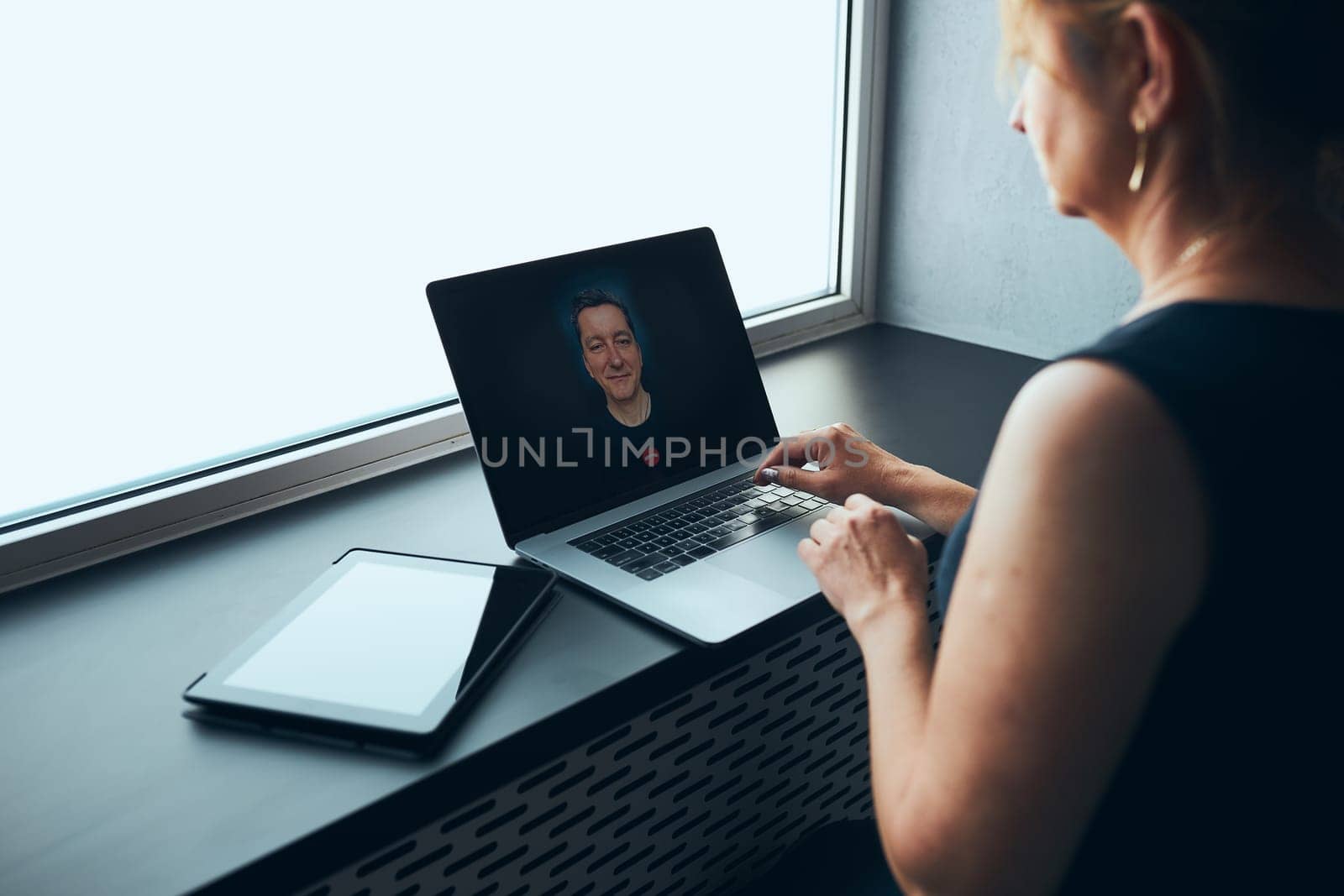 Businesswoman having business video call on laptop in office. Mature busy woman remotely working from office. Female manager using digital devices. Remote communication. Video calling. Remote work