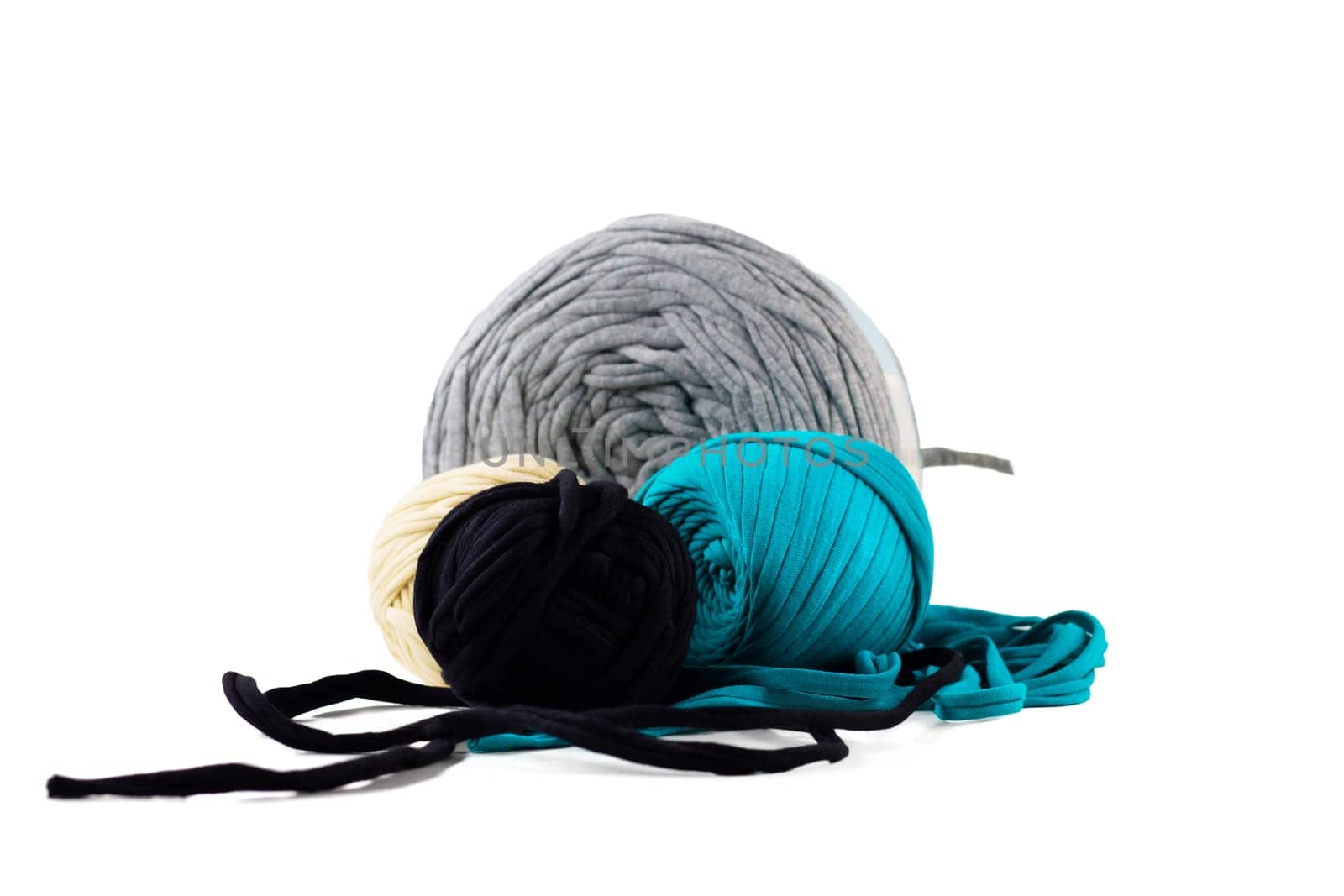 Skeins of turquoise, black, gray, beige knitted yarn, isolated on white background