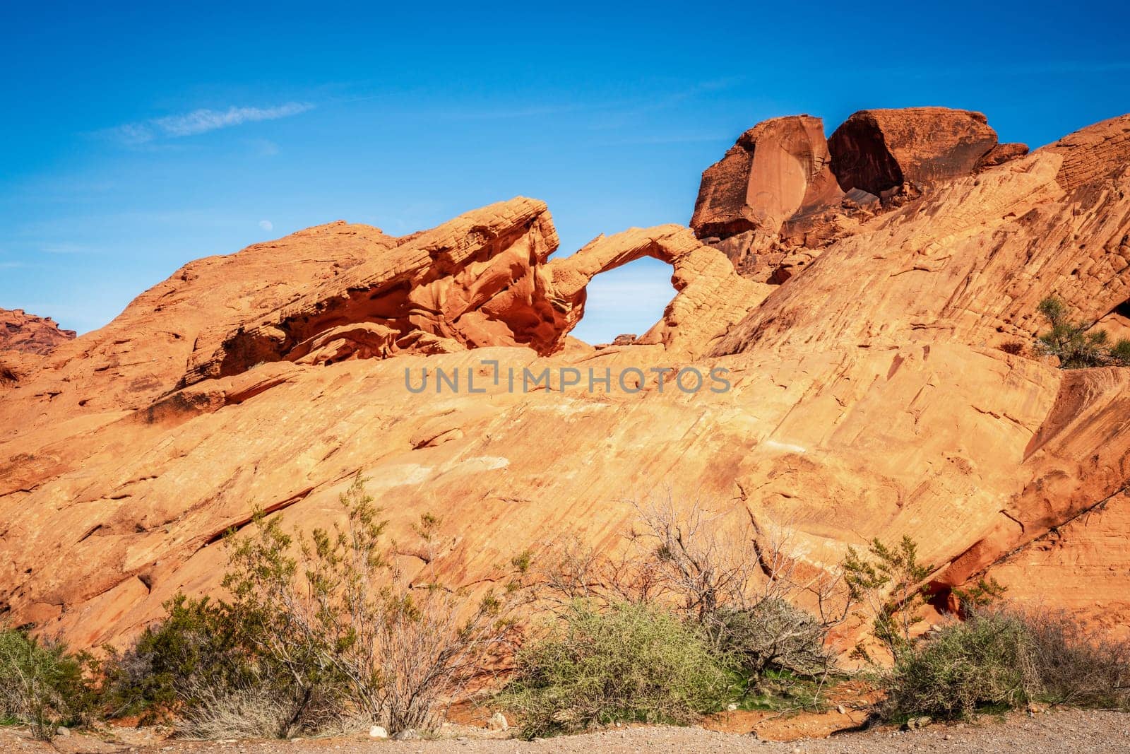 Moon rising over Arch Rock formation in Valley of Fire State Park in Nevada
