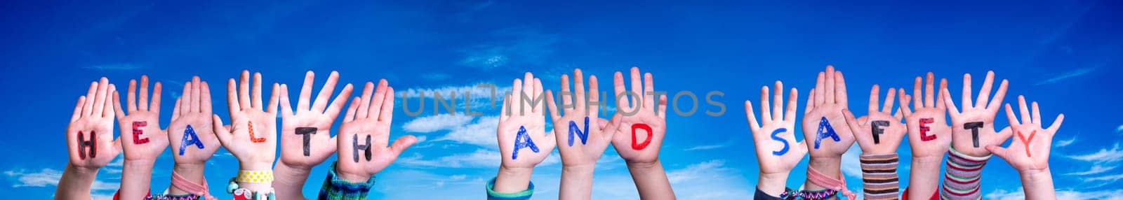 Children Hands Building Colorful English Word Health And Safety. Blue Sky As Background.