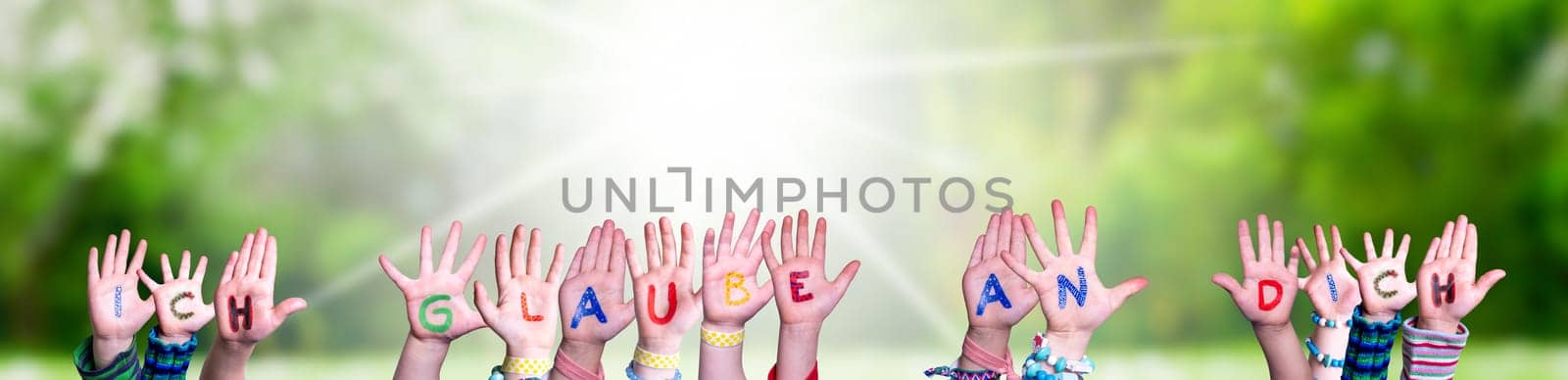 Children Hands Building Colorful German Word Ich Glaube An Dich Means I Believe In You. Sunny Green Grass Meadow As Background.