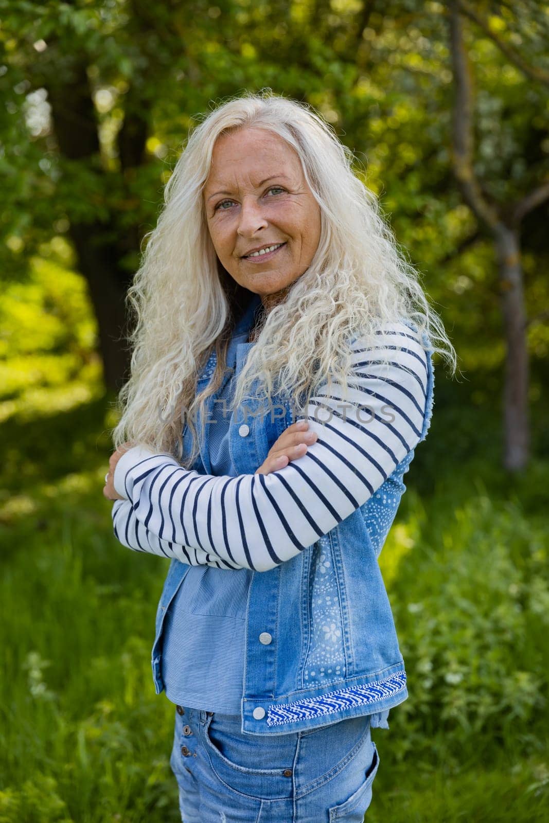 Beautiful elderly woman with her arms crossed in a public Park