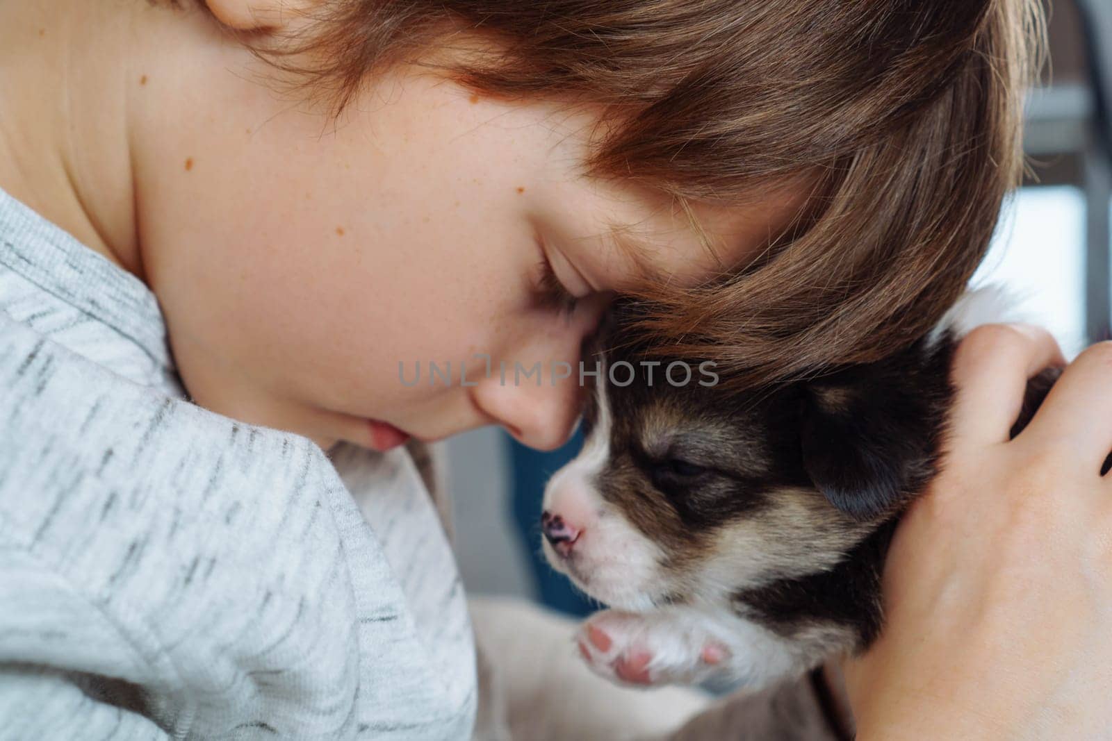 Problems of teenagers, loneliness, misunderstanding. Frustrated teenage boy sits with his eyes closed and hugs his puppy friend. Children and dogs. Depression. Psychological help. Abusing. Negativity.