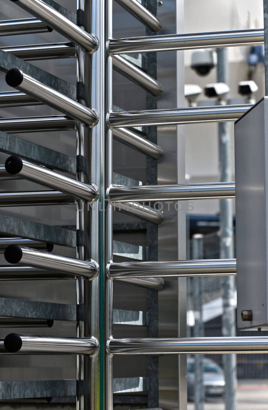 Full-height turnstile guarded stadium entrance. Revolving door