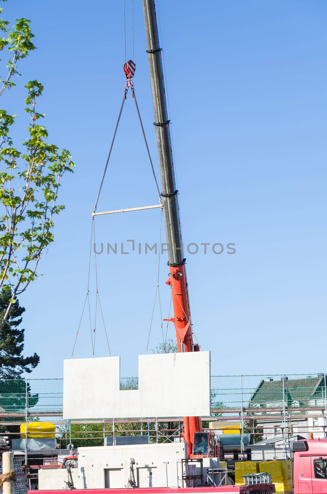 Mobile construction crane wagon on a construction site. Lifts up a concrete finished wall.