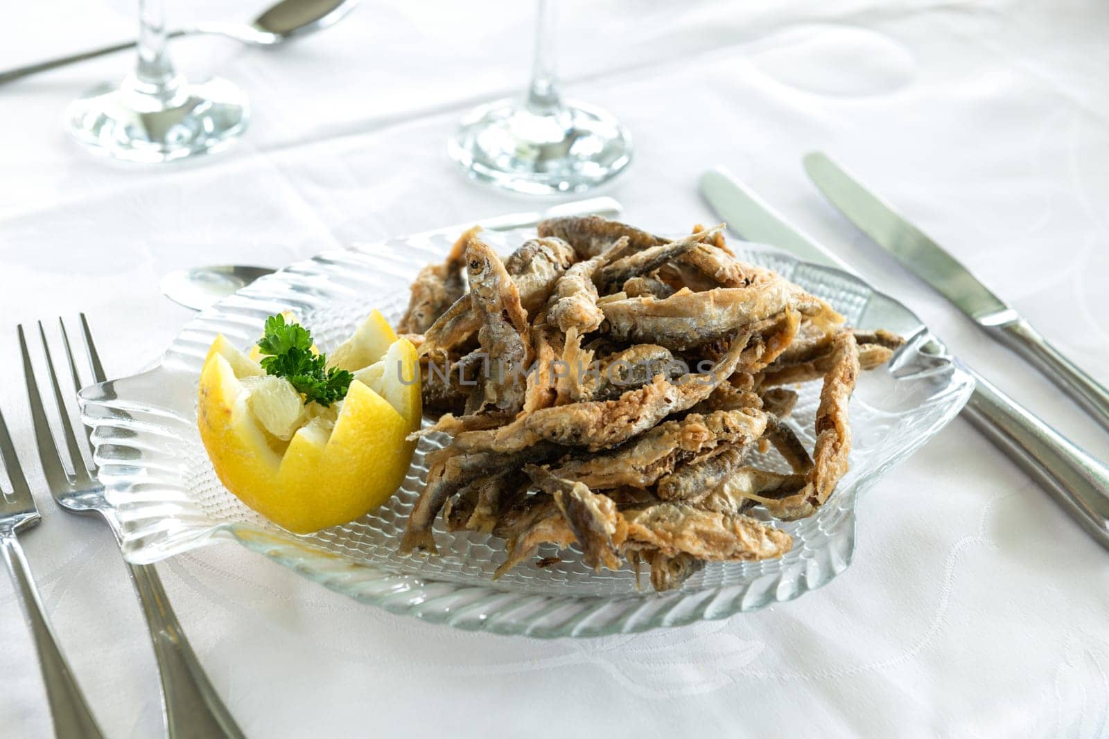 Plate of fried small freshwater fish with lemon