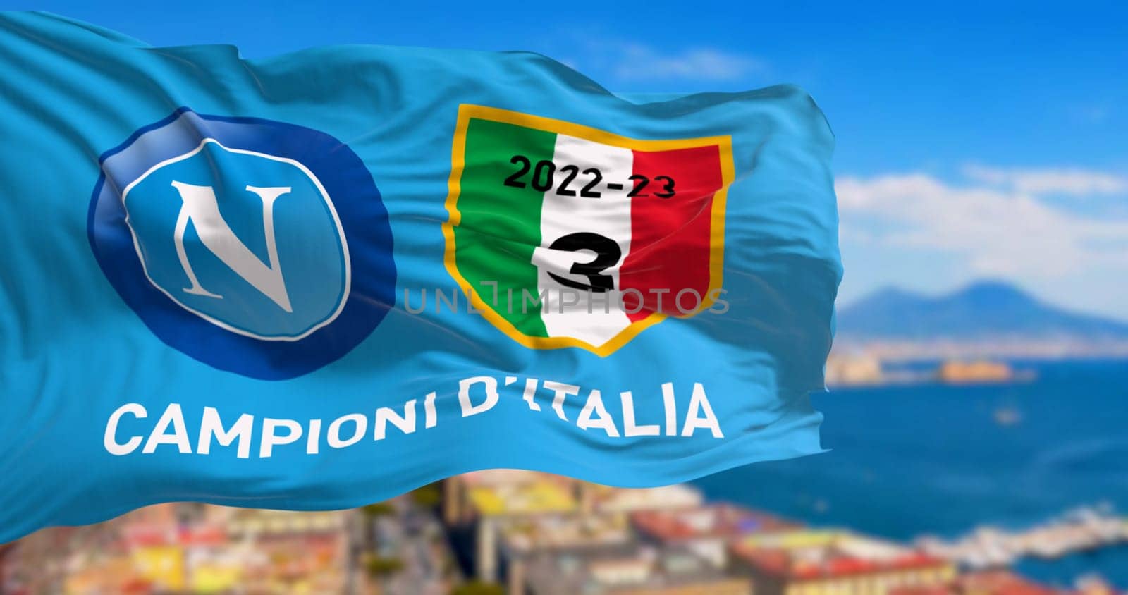 Naples, IT, april 2023: The celebratory flag for Napoli third championship victory waving with the Gulf of Naples blurred in the background. Illustrative editorial 3d illustration render