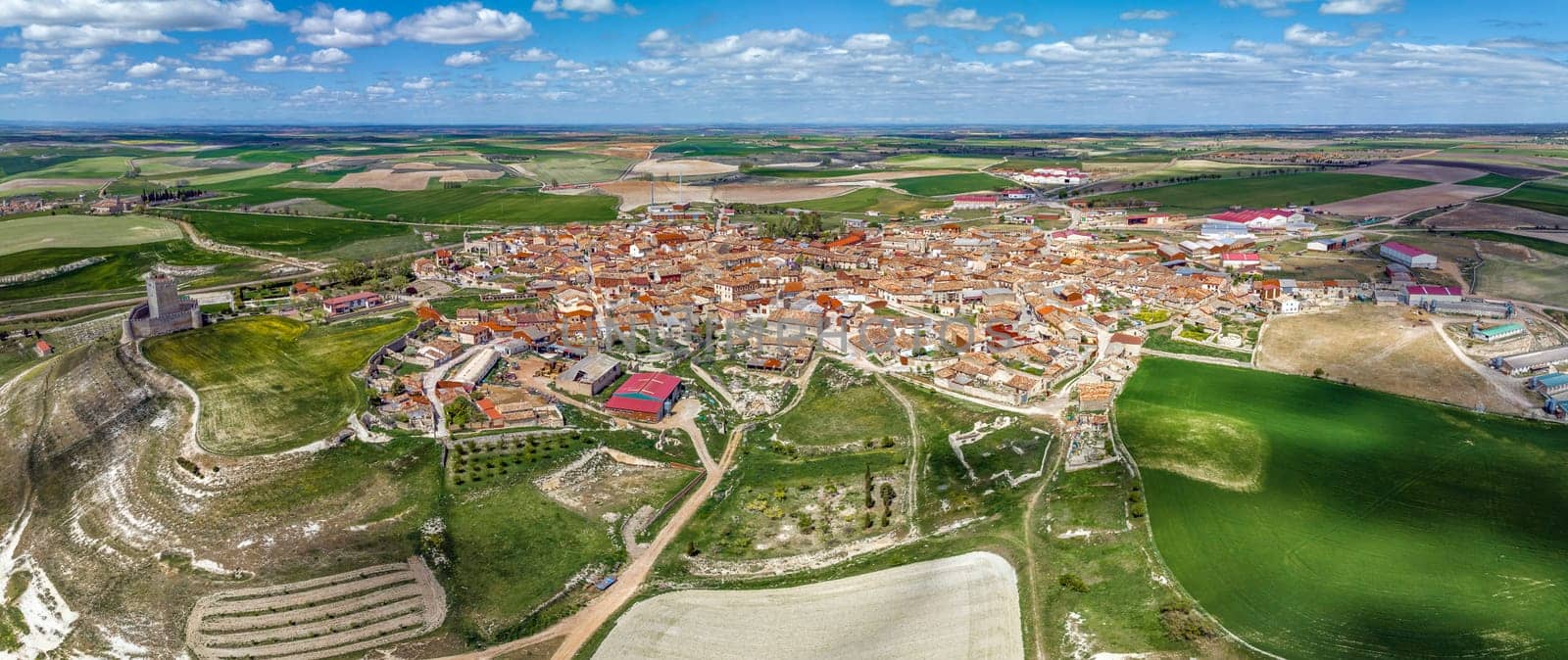 Aerial view Panoramic of the town of Tiedra in the province of Valladolid in Spain, with surrounding agricultural fields. Highlighting the tower of the castle on the typical houses of the town