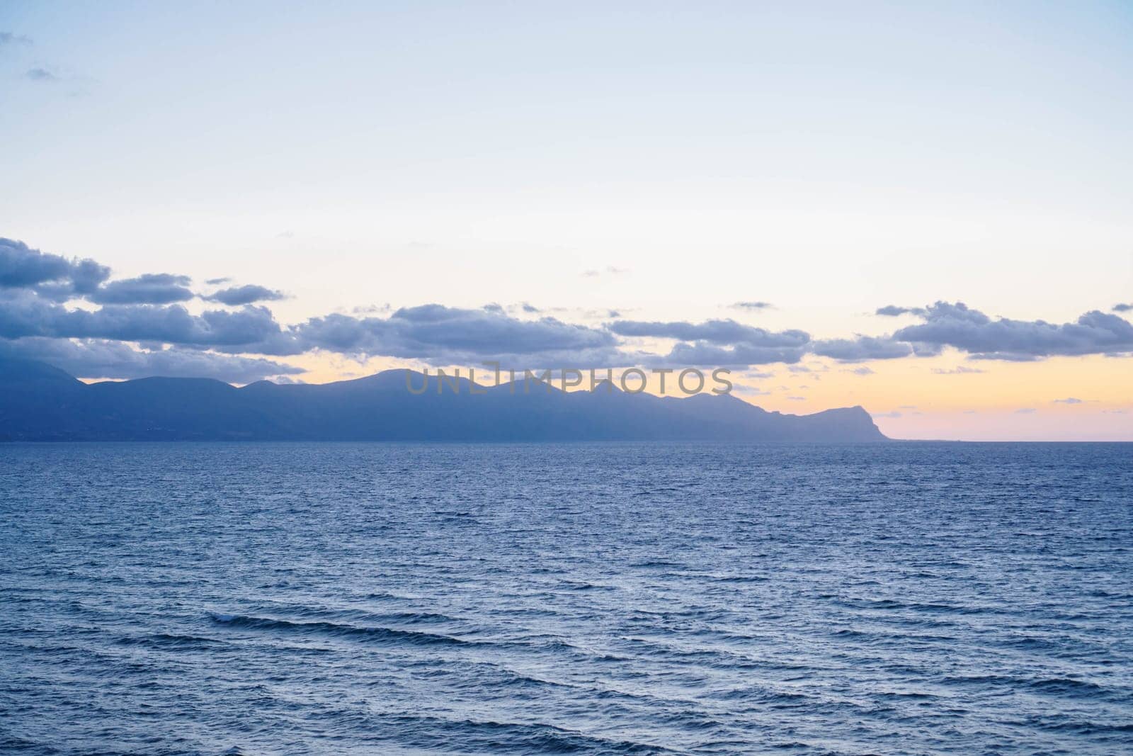 Sunset on sea. Rays of setting sun between clouds above sea surface. Meditation and relaxation. Wonderful moments of life. Tourism and travel. Splendor of nature. Rest . Enjoying beautiful.