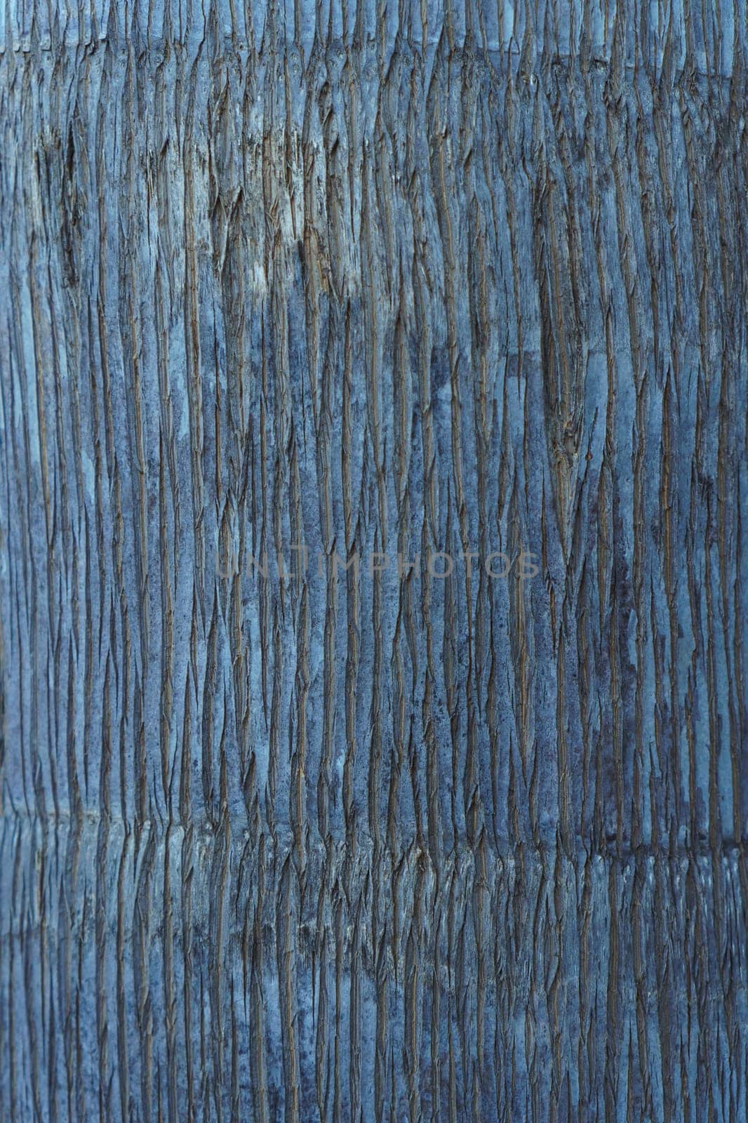 Close-up. Textured natural indigo coating, with vertical pattern of uneven stripes. Colored background. Modern wallpaper and plaster. Use of natural materials and dyes. Interior design.