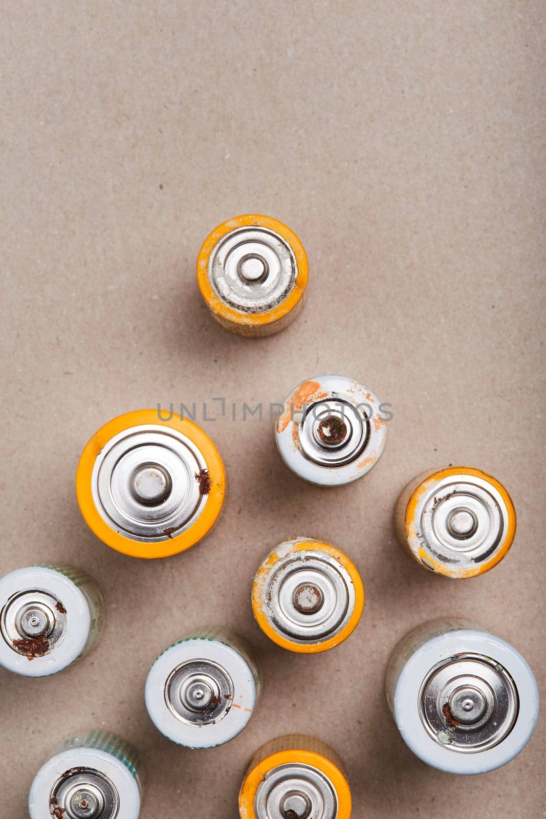 Discharged batteries on paper background. Collecting used batteries to recycle. Waste disposal and recycling. Copy space for text