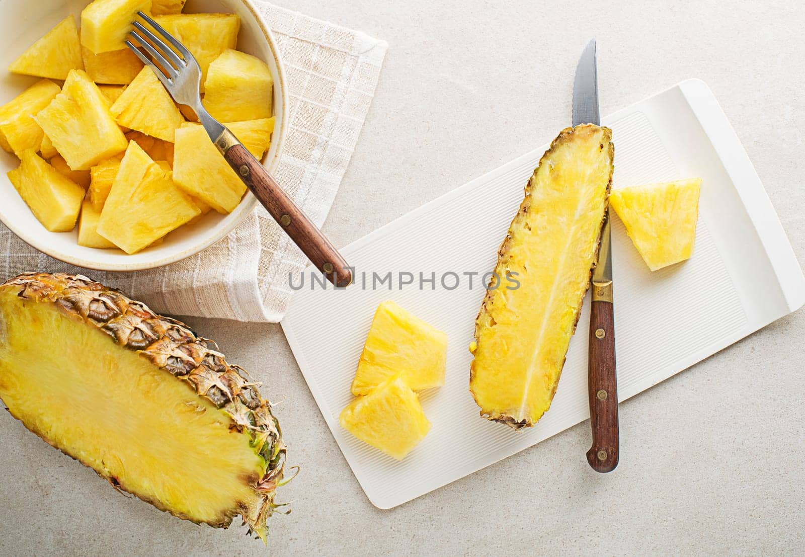 Fresh sliced pineapple on white bright table background, top view closeup
