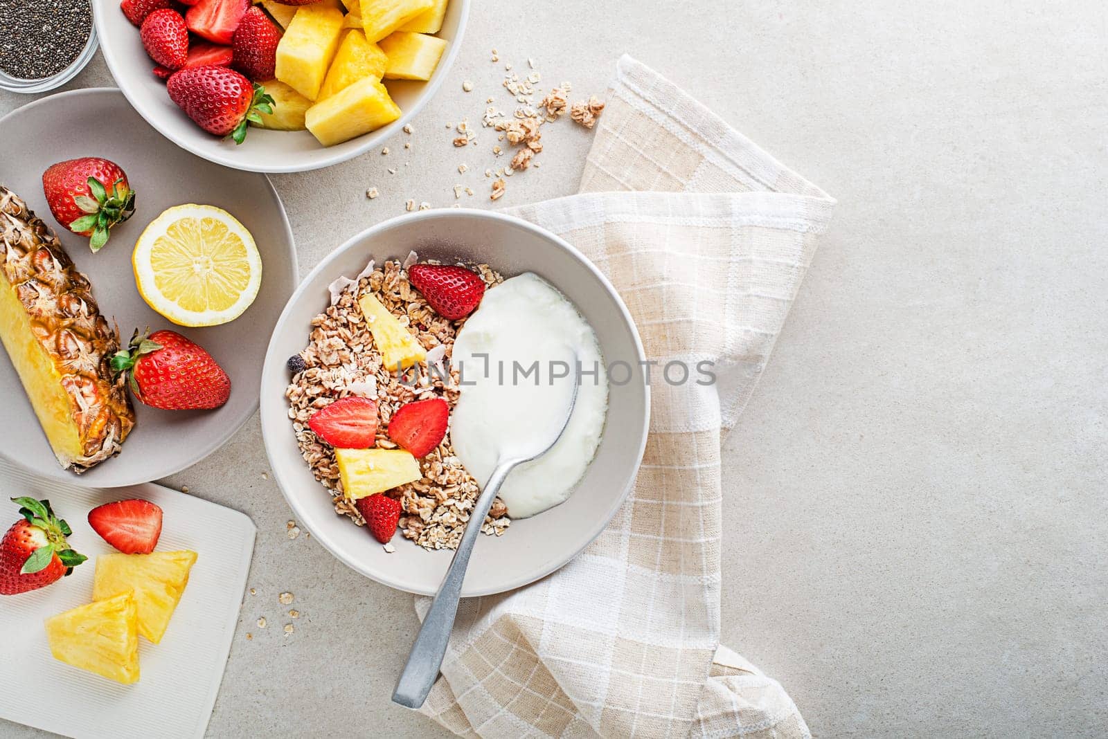 A bowl of dry granola served with fresh fruit and yogurt. Oatmeal plate. Healthy food, diet. Top view.