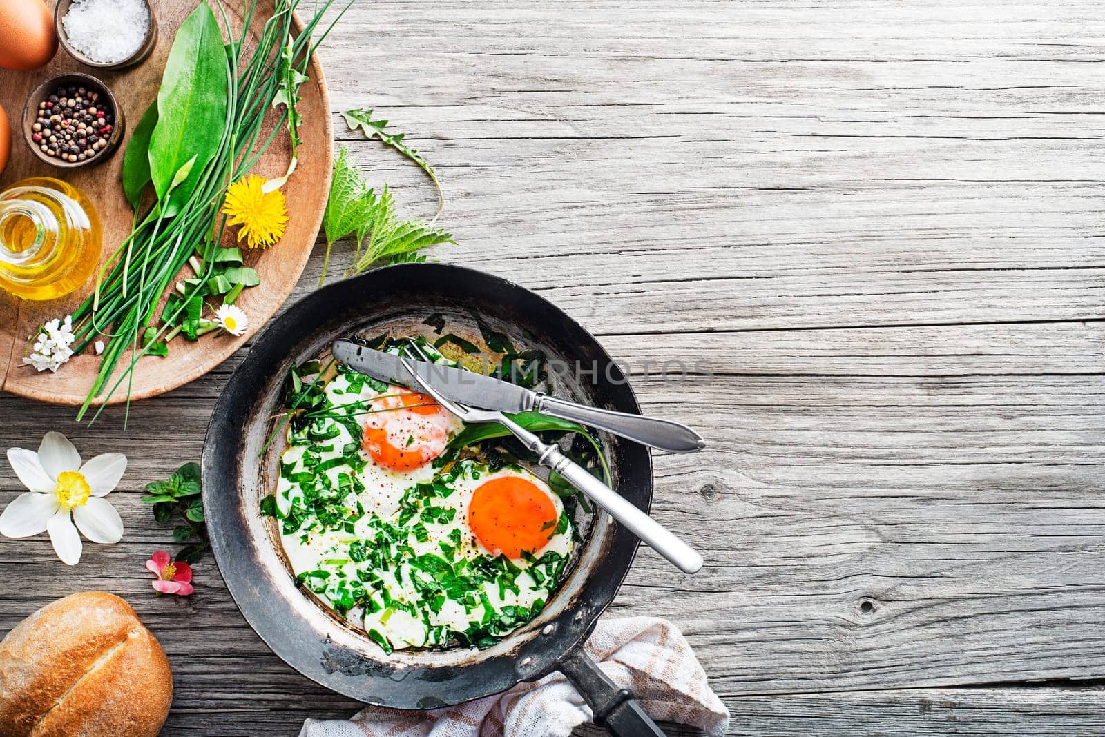 Fried eggs with fresh spring plants and herbs. Healthy spring food concept.