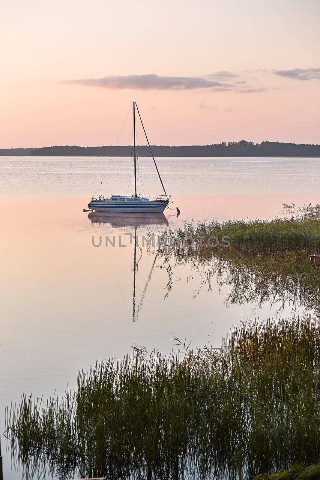 Yacht moored near a harbour in coast at sunrise. Candid people, real moments, authentic situations