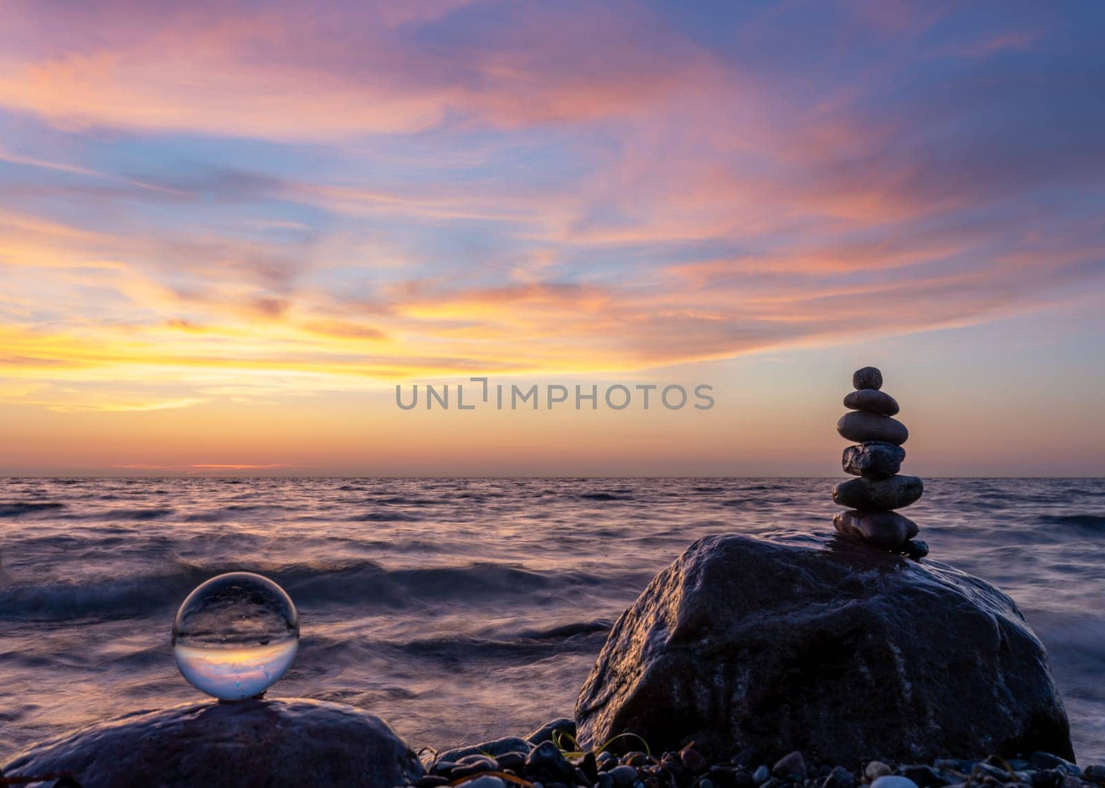 Stone pyramids and glass sphere on the dreamy Baltic Sea sand beach on Rügen for the spectacular sunset