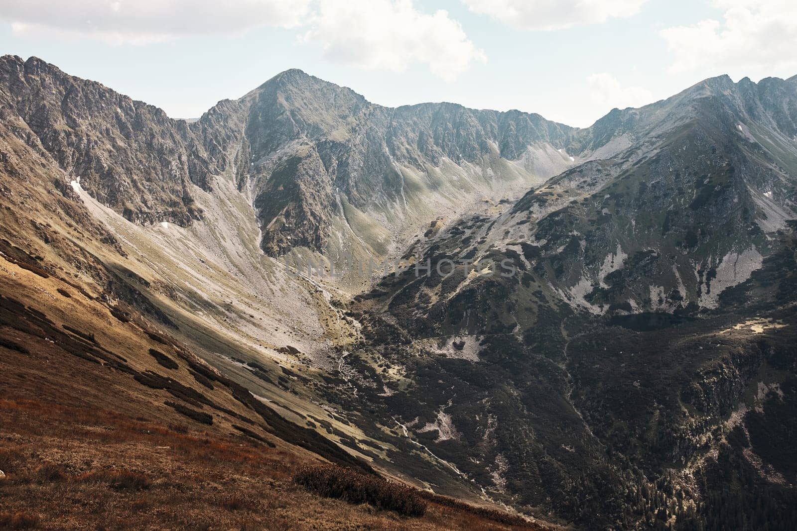 Tatra Mountains landscape. Scenic view of mountain rocky peaks, slopes, hills and valleys covered with grass, mugo pine and trees