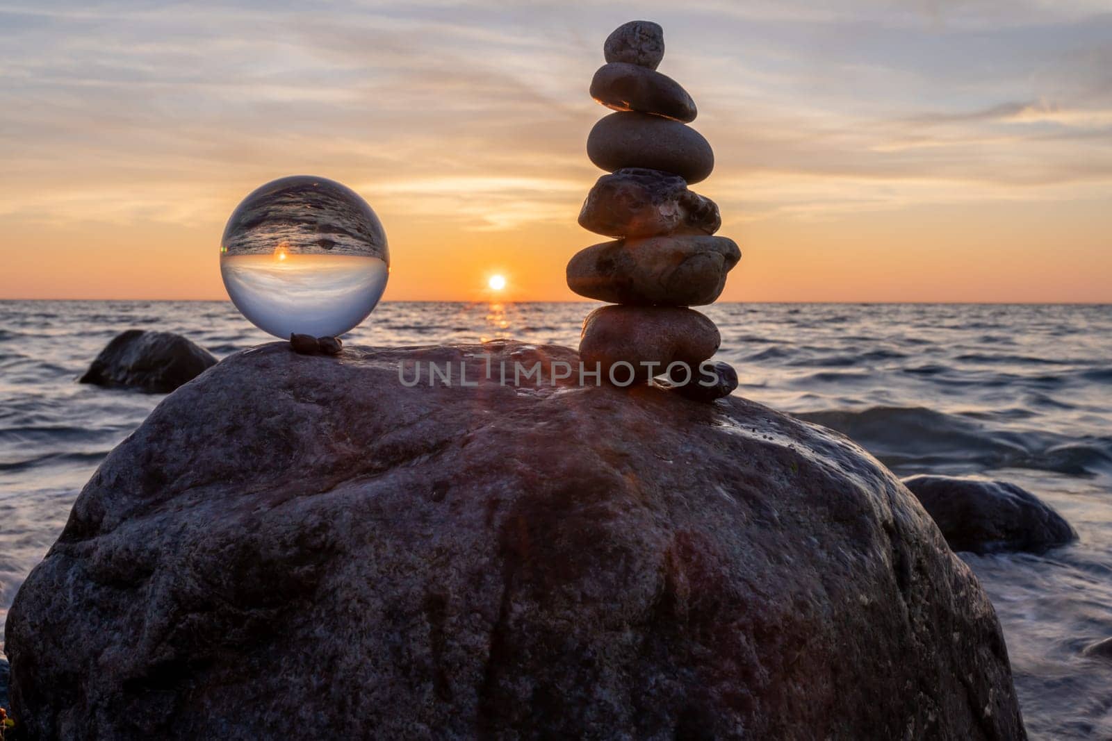 Stone pyramids and glass sphere on the dreamy Baltic Sea sand beach on Rügen for the spectacular sunset