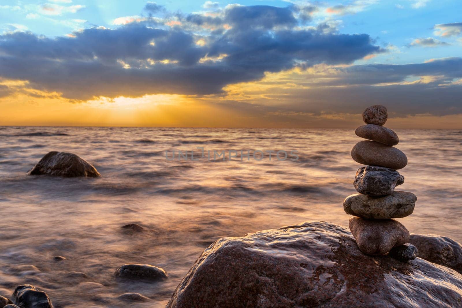 Stone pyramids and glass sphere on the dreamy Baltic Sea sand beach on Rügen for the spectacular sunset