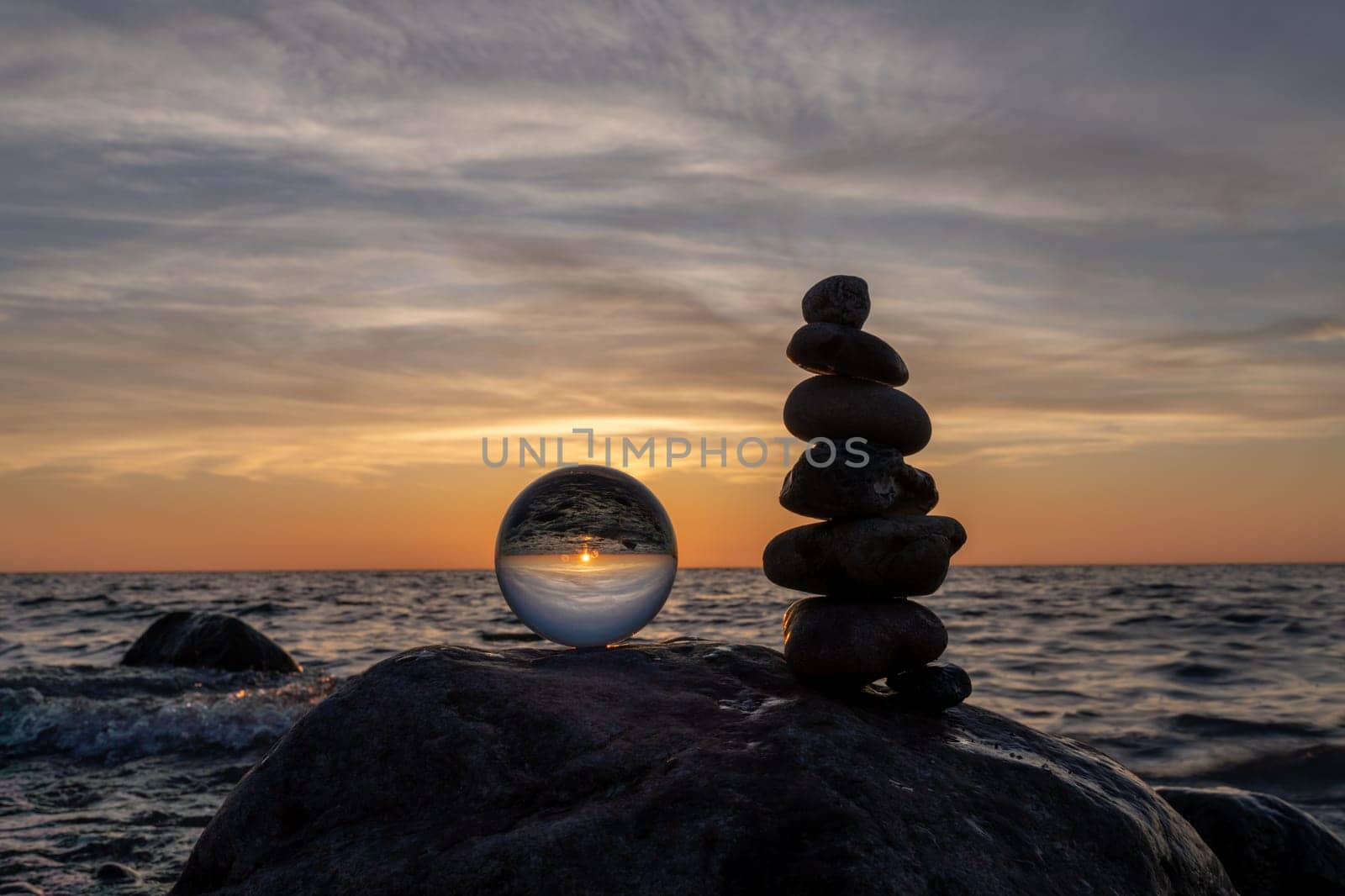 Stone pyramids and glass sphere on the dreamy Baltic Sea sand beach on Rügen for the spectacular sunset