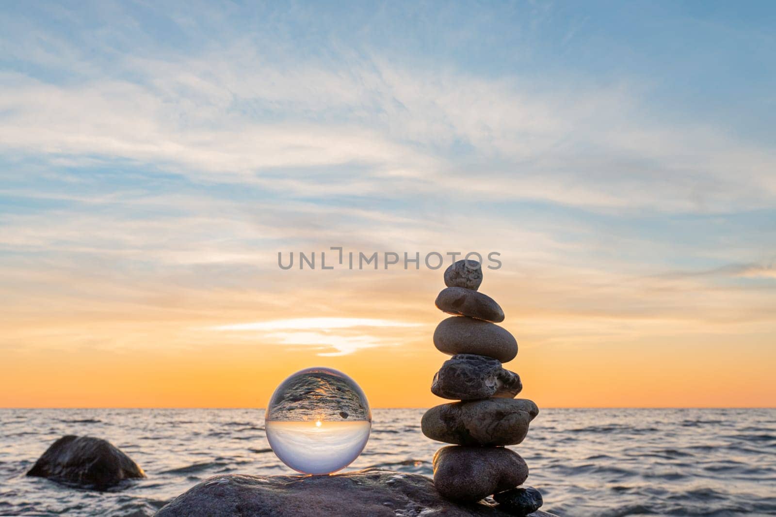 Stone pyramids and glass sphere on the dreamy Baltic Sea sand beach on Rügen for the spectacular sunset